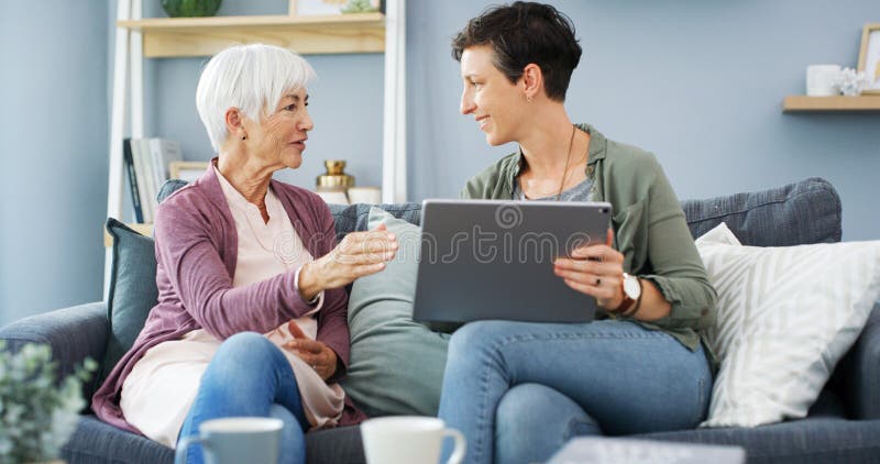Apprendimento a tavolette e donna con madre anziana sul divano per chiacchierare o per la messa in rete. Tecnologia digitale fotografie stock libere da diritti