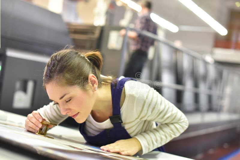 Apprendista della giovane donna nella stampa indutry immagine stock libera da diritti Apprendista della giovane donna nella stampa indutry immagine stock libera da diritti
