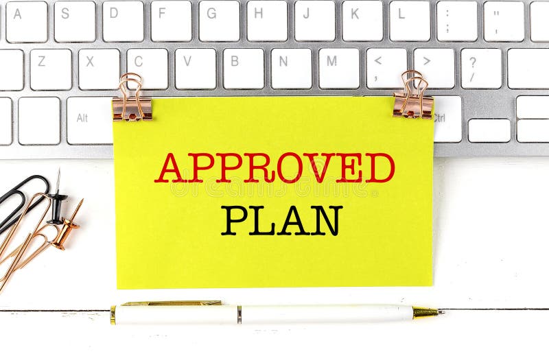 APPROVED PLAN text on yellow sticky on keyboard royalty free stock photography