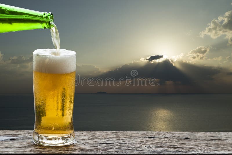 Appréciez la bière avec le paysage de mer de coucher du soleil images stock Appréciez la bière avec le paysage de mer de coucher du soleil images stock