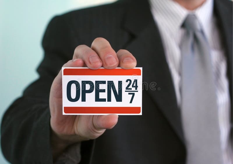 Man holding a sign that says Open 24/7. Online support, store opening, and other business-related customer service concepts. Man holding a sign that says Open 24/7. Online support, store opening, and other business-related customer service concepts