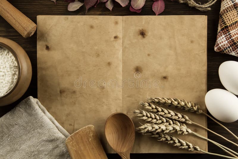 Apra il libro d'annata sui precedenti di legno invecchiati Utensili della cucina, orecchie di grano, farina in un vaso casalingo, fotografia stock libera da diritti Apra il libro d'annata sui precedenti di legno invecchiati Utensili della cucina, orecchie di grano, farina in un vaso casalingo, fotografia stock libera da diritti