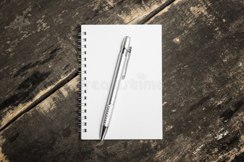 Apra il taccuino in bianco con la matita d'argento sul backgroun di legno di lerciume fotografia stock Apra il taccuino in bianco con la matita d'argento sul backgroun di legno di lerciume fotografia stock