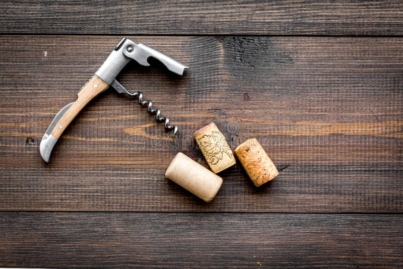 Apra la bottiglia di vino Sugheri e cavaturaccioli sul copyspace di legno scuro di vista superiore del fondo fotografia stock Apra la bottiglia di vino Sugheri e cavaturaccioli sul copyspace di legno scuro di vista superiore del fondo fotografia stock