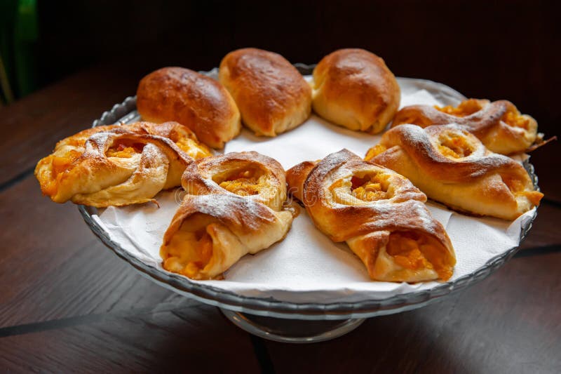 Apricot Danish pastries on a white napkin. The cakes are served in a tall glass vase. Close-up, selective focus