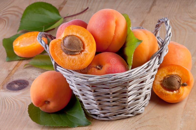 Apricots in Basket on Wooden Background