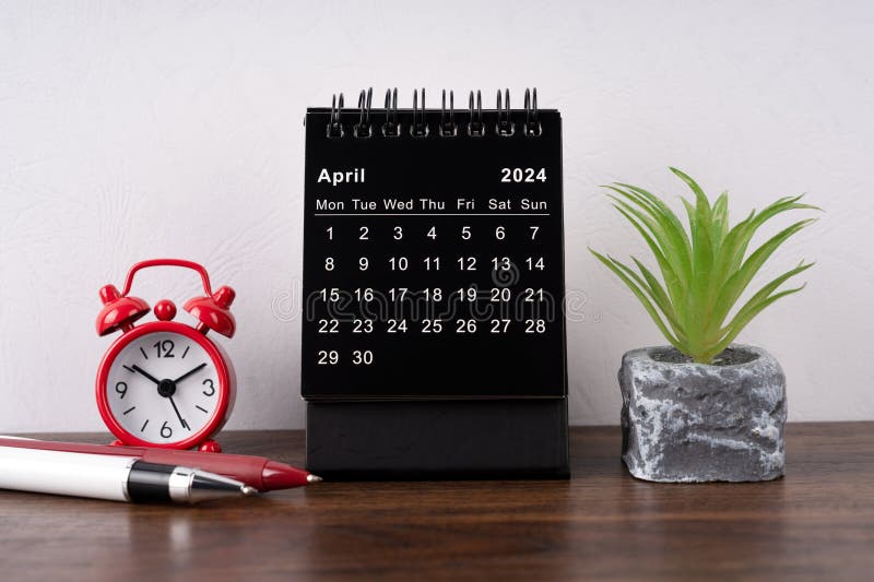 April 2024 desk calendar, alarm clock and potted plant