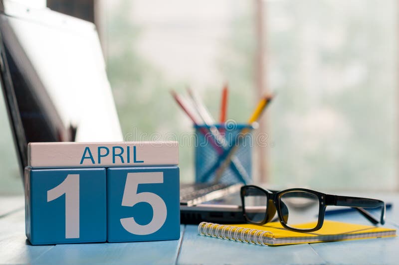 April 15th. Day 15 of month, calendar on business office background, workplace with laptop and glasses. Spring time royalty free stock photo