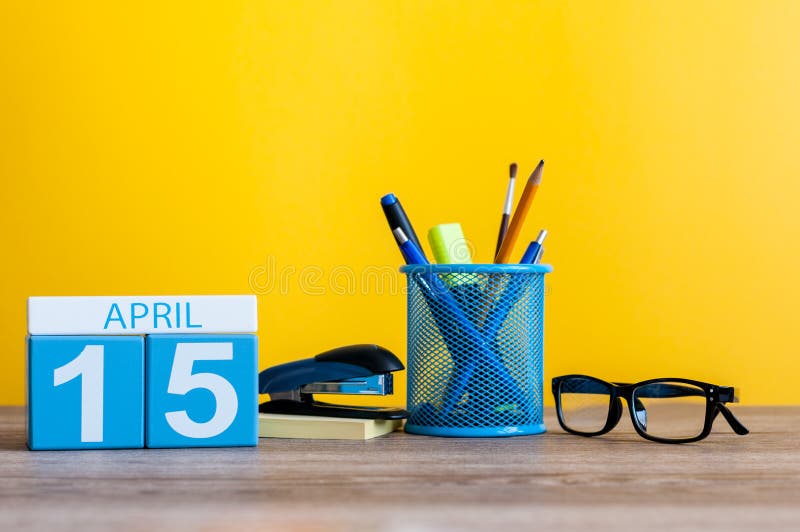 April 15th. Day 15 of month, calendar on business office table, workplace with yellow background. Spring time royalty free stock photo