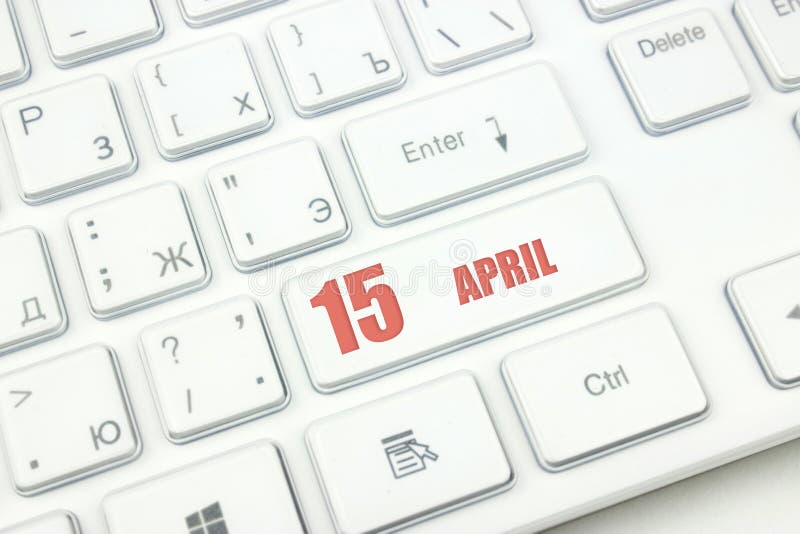 April 15th. Day 15 of month, Calendar date. Cropped view of Modern White Computer Keyboard with calendar date. Concept workspace royalty free stock images