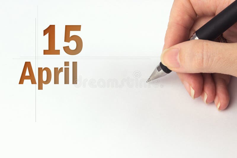 April 15th. Day 15 of month, Calendar date. The hand holds a black pen and writes the calendar date. Spring month, day of the year stock images