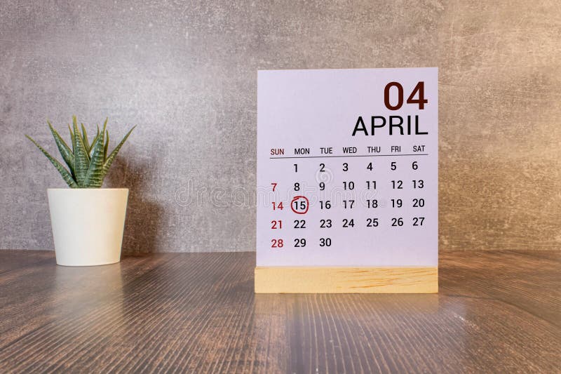 April 15th. Day 15 of month, calendar on wooden table and turquoise background. royalty free stock image