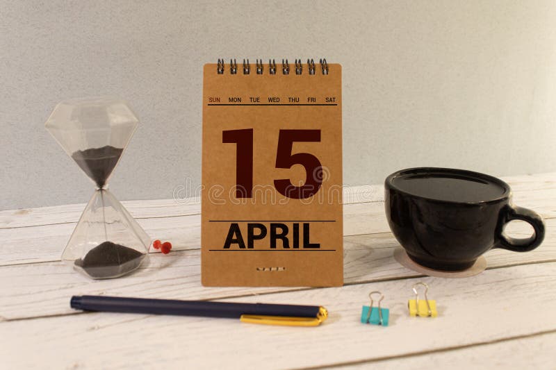 April 15th. Day 15 of month, calendar on wooden table and turquoise background. royalty free stock image
