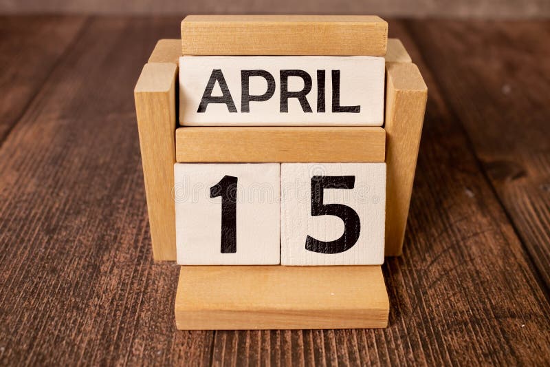 April 15th. Day 15 of month, calendar on wooden table and turquoise background. royalty free stock image