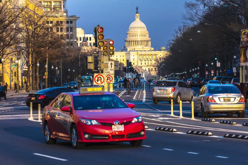 APRIL 11, 2018 WASHINGTON D.C. - Red car down Pennsylvania Ave to US Capitol going towards US Capitol in Washington DC. during rush hour PM. APRIL 11, 2018 WASHINGTON D.C. - Red car down Pennsylvania Ave to US Capitol going towards US Capitol in Washington DC. during rush hour PM