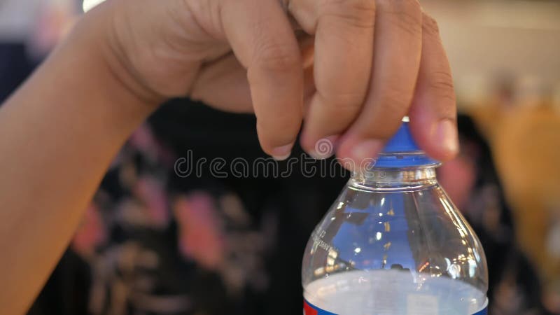 Aprire un tappo di una bottiglia d'acqua di plastica