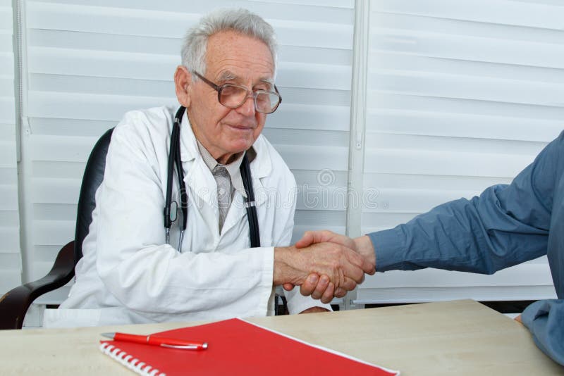 Après que le docteur et le patient de consultation se serrent la main photographie stock Après que le docteur et le patient de consultation se serrent la main photographie stock