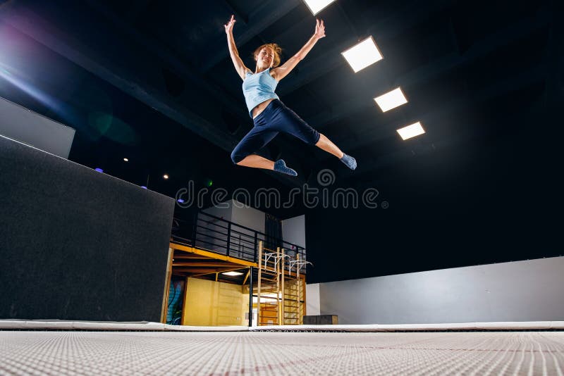 Aptidão do desportista da jovem mulher que salta no trampolim do clube imagens de stock royalty free Aptidão do desportista da jovem mulher que salta no trampolim do clube imagens de stock royalty free