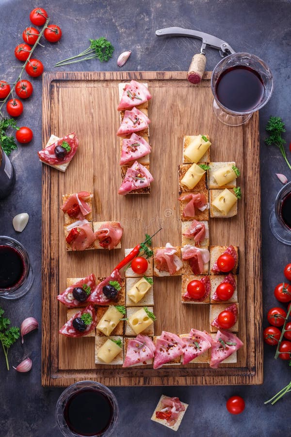 Aptitretare bordlägger med italienska antipastimellanmål och vin i exponeringsglas Brushetta eller autentiska traditionella spans royaltyfri foto Aptitretare bordlägger med italienska antipastimellanmål och vin i exponeringsglas Brushetta eller autentiska traditionella spans royaltyfri foto