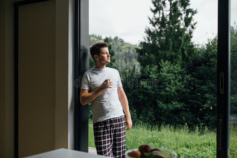Apuesto hombre disfrutando de café caliente en la mañana soleada en las montañas. espacio para texto. tranquilidad fotos de archivo libres de regalías