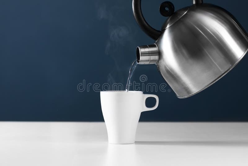 Apă de tip retro cetonă turnată într-o cupă pe fond alb cu fum pe masa din lemn royalty free stock images
