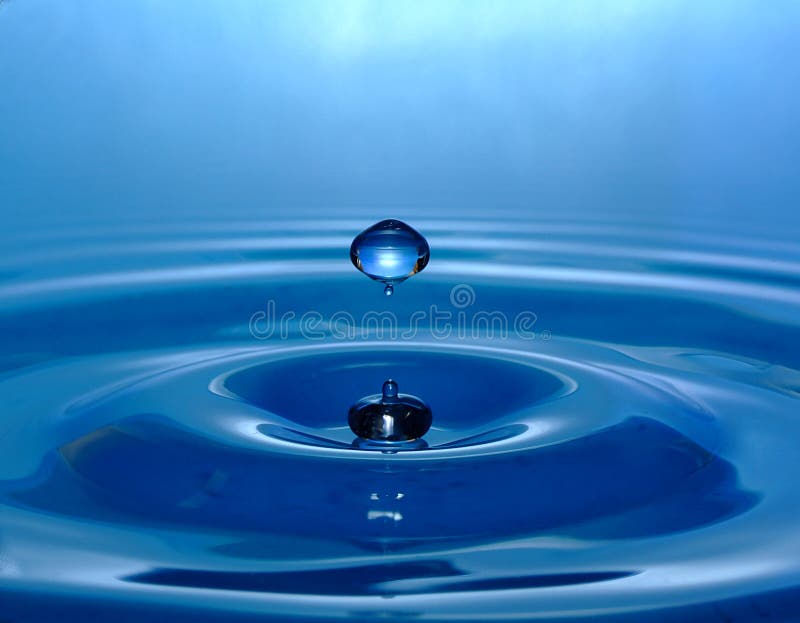 Aqua blue water droplet rebounding off the surface of the water. Aqua blue water droplet rebounding off the surface of the water