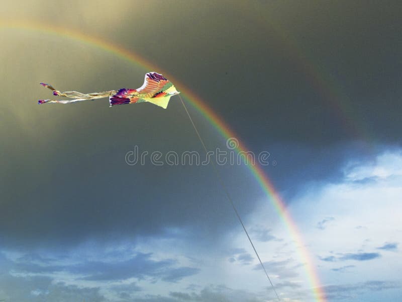 aquilone-luminoso-sotto-forma-di-uccello-nel-cielo-con-un-arcobaleno-e-le-nuvole-scure-estate-124511408