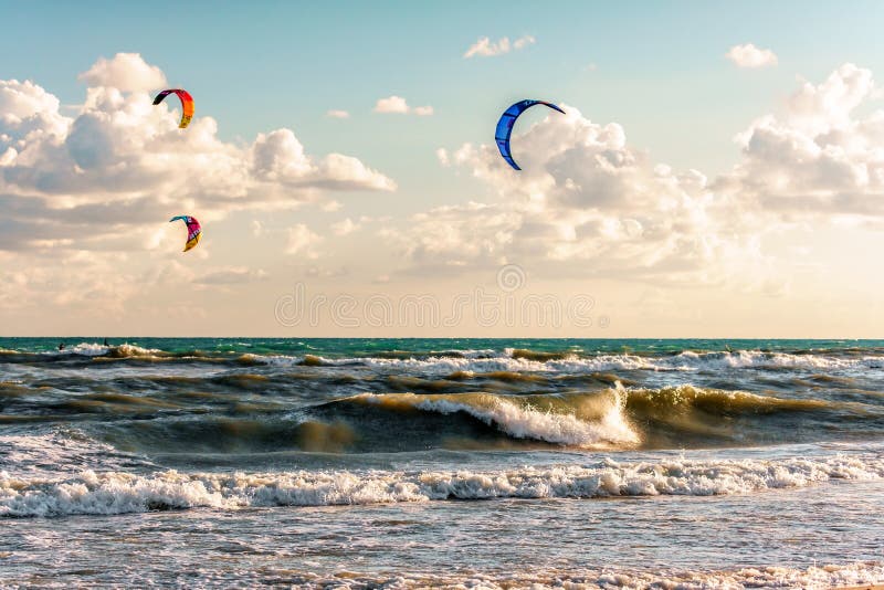 Aquiloni di giro di Kitesurfers attraverso le onde praticanti il surfing del mare tempestoso alla stazione balneare di Blaga al t fotografie stock libere da diritti Aquiloni di giro di Kitesurfers attraverso le onde praticanti il surfing del mare tempestoso alla stazione balneare di Blaga al t fotografie stock libere da diritti
