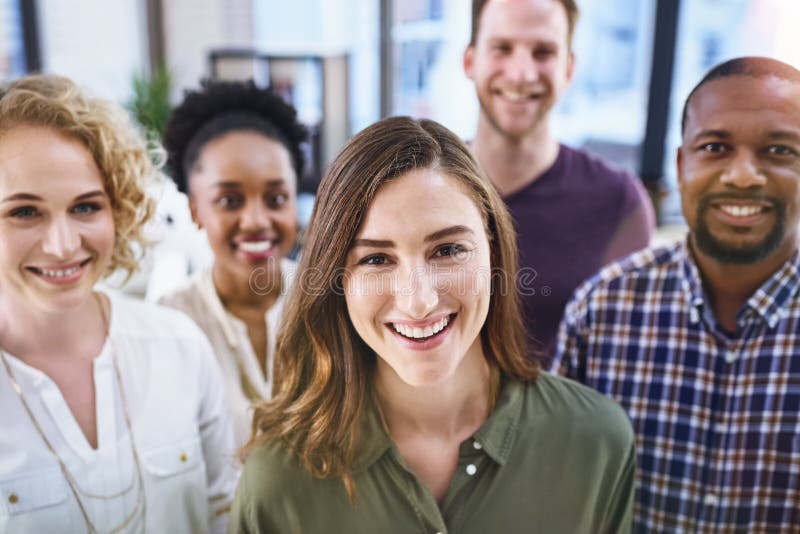 Aquí para brindarle el servicio más eficiente. retrato de un equipo de diseñadores parados juntos en la oficina. imagen de archivo