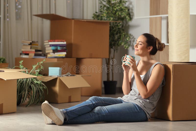 Happy tenant moving home resting breathing fresh air sitting on the floor in the night. Happy tenant moving home resting breathing fresh air sitting on the floor in the night