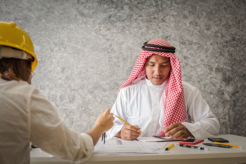 Arab engineer working with workmate in contractor office royalty free stock image