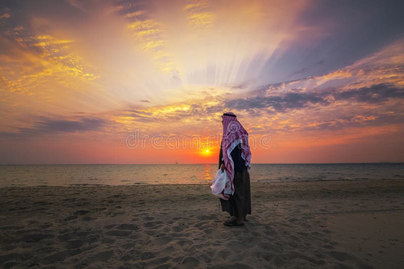 Arab staruszek stojący na plaży Fanateer z wschodem słońca Al-Jubail City