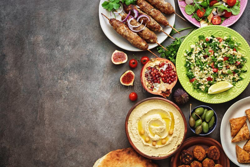 Arabic and Middle Eastern dinner table. Hummus, tabbouleh salad, Fattoush salad, pita, meat kebab, falafel, baklava, pomegranate. royalty free stock photo