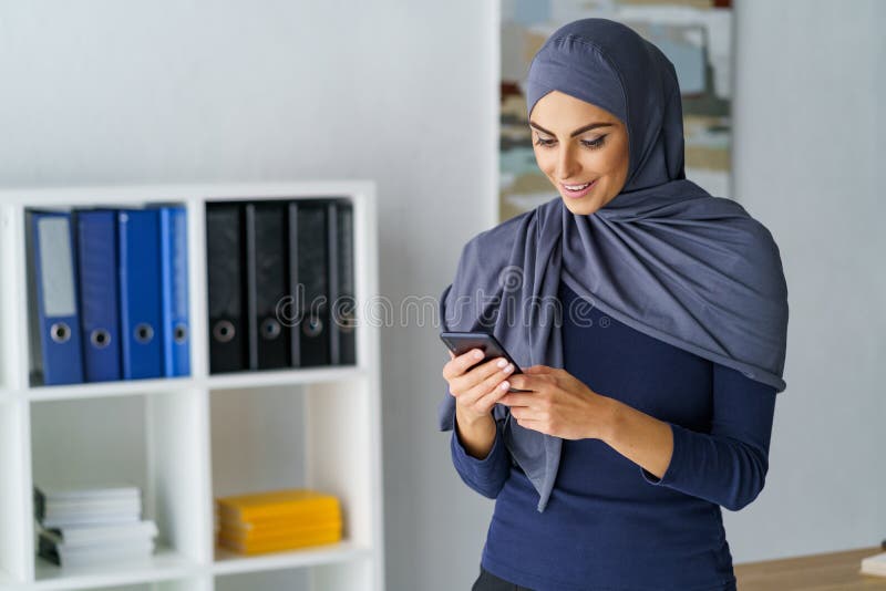 Arabische Frau, die Telefon betrachtet stockfotos Arabische Frau, die Telefon betrachtet stockfotos