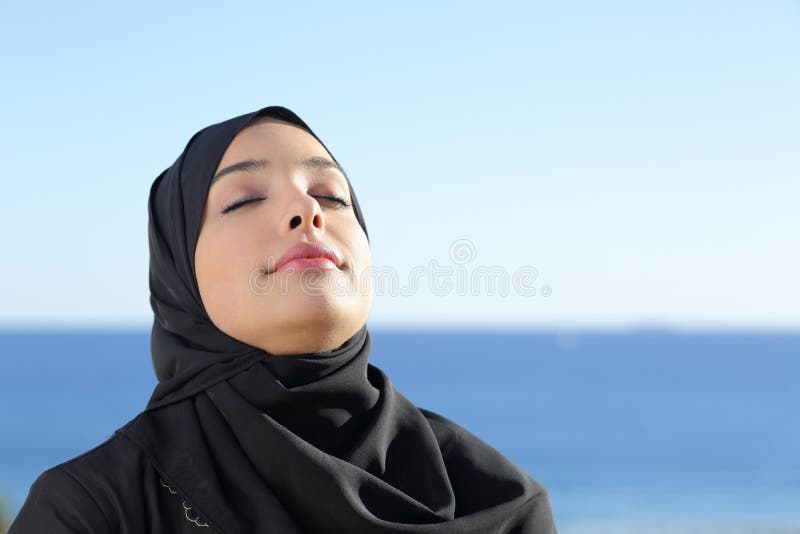 Arabische Saoedi-arabische vrouw die diepe verse lucht in het strand ademen