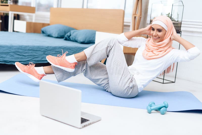 Arabische vrouw die gymnastiek in de slaapkamer doen royalty-vrije stock afbeelding Arabische vrouw die gymnastiek in de slaapkamer doen royalty-vrije stock afbeelding
