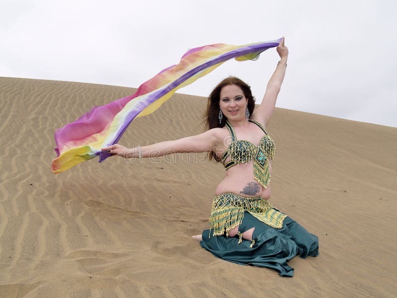 Arabischer Tänzer mit einem Farbentuch an der Wüste