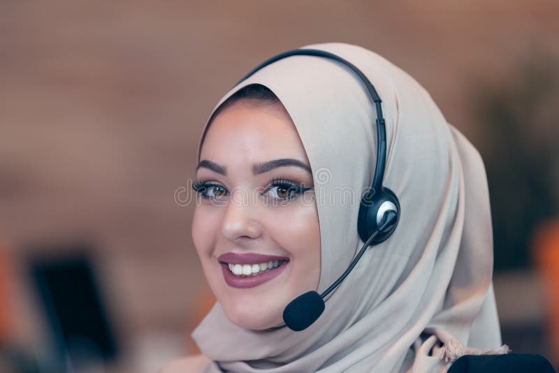 Arabisk kvinna för härlig telefonoperatör som arbetar i startup kontor royaltyfria foton Arabisk kvinna för härlig telefonoperatör som arbetar i startup kontor royaltyfria foton