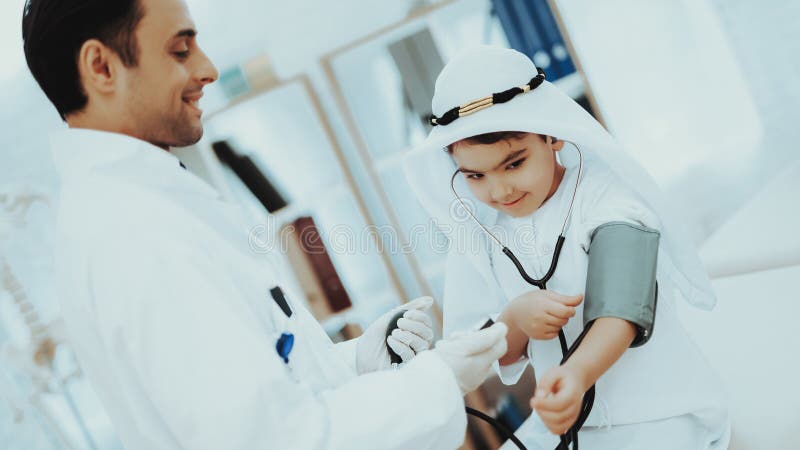 Arabisk manlig pojke för doktor Checking Blood Pressure arkivfoton Arabisk manlig pojke för doktor Checking Blood Pressure arkivfoton