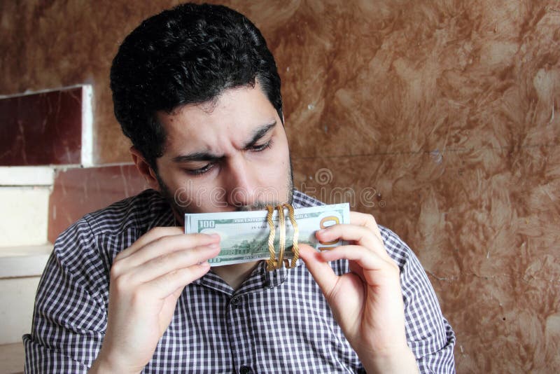 Arabisk ung affärsman med dollarräkningar och guld- smycken royaltyfri bild Arabisk ung affärsman med dollarräkningar och guld- smycken royaltyfri bild