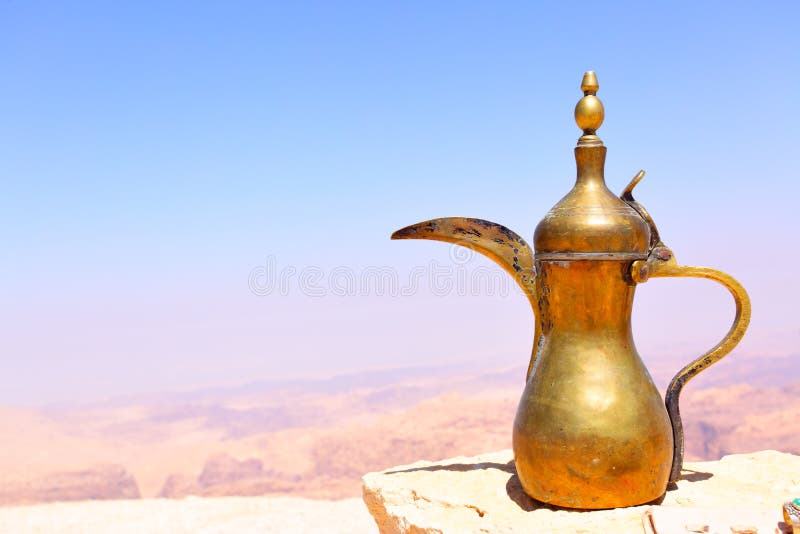 Arabic coffee pot on the stone and Jordan's mountains in the background. Arabic coffee pot on the stone and Jordan's mountains in the background