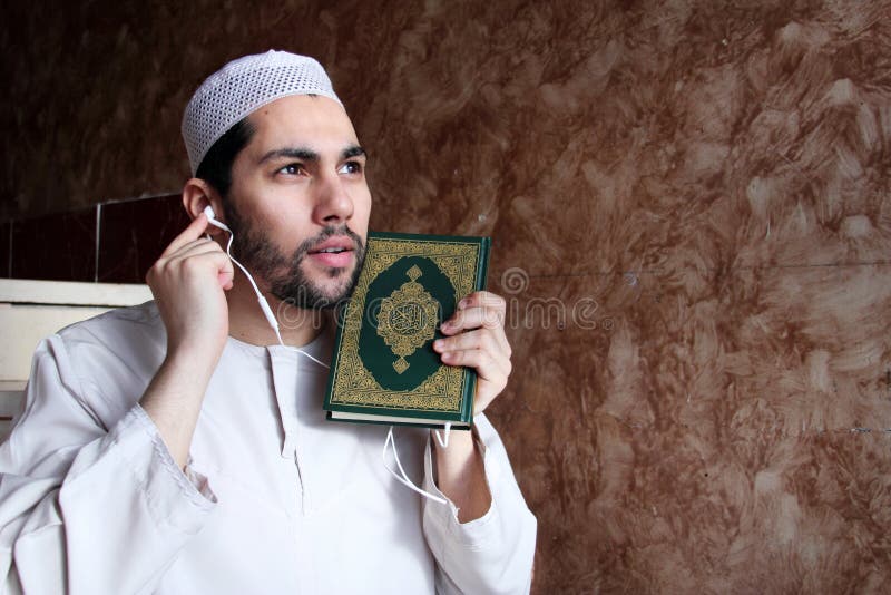 Arabian egyptian muslim man put headset into koran holy book to play quran verses like modern music player. it is symbol of concept there is no time to read. Arabian egyptian muslim man put headset into koran holy book to play quran verses like modern music player. it is symbol of concept there is no time to read