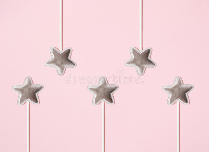 Am aranjat cinci steluțe argintii pe un băț. fond roz. design minim. copiere spațiu. plat royalty free stock image