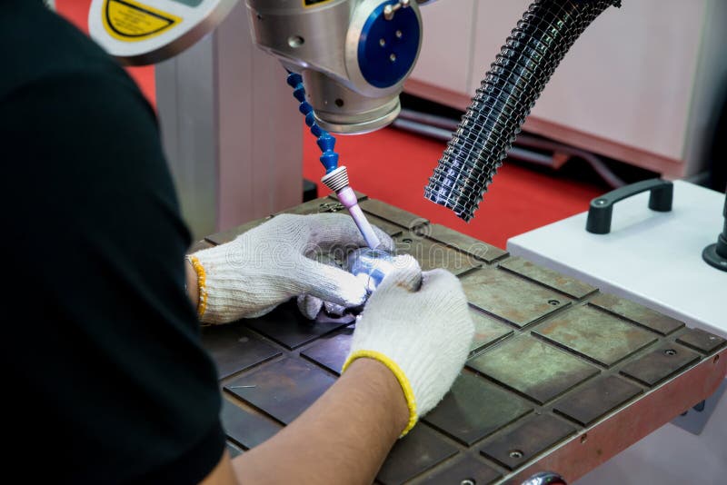 Arbeider die reparatievorm en matrijzendeel gebruiken door machine van het Laserlassen i royalty-vrije stock foto's Arbeider die reparatievorm en matrijzendeel gebruiken door machine van het Laserlassen i royalty-vrije stock foto's