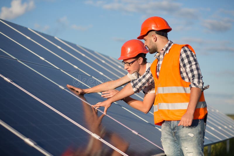 Worker and foreman maintaining solar energy panel. Technicians checking equipment for solar energy station. Worker and foreman maintaining solar energy panel. Technicians checking equipment for solar energy station.