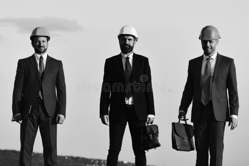 Arbeiders en ingenieursgreepvergadering in openlucht Coworking en bouwvakconcept Voormannen huidig groepswerk stock fotografie Arbeiders en ingenieursgreepvergadering in openlucht Coworking en bouwvakconcept Voormannen huidig groepswerk stock fotografie