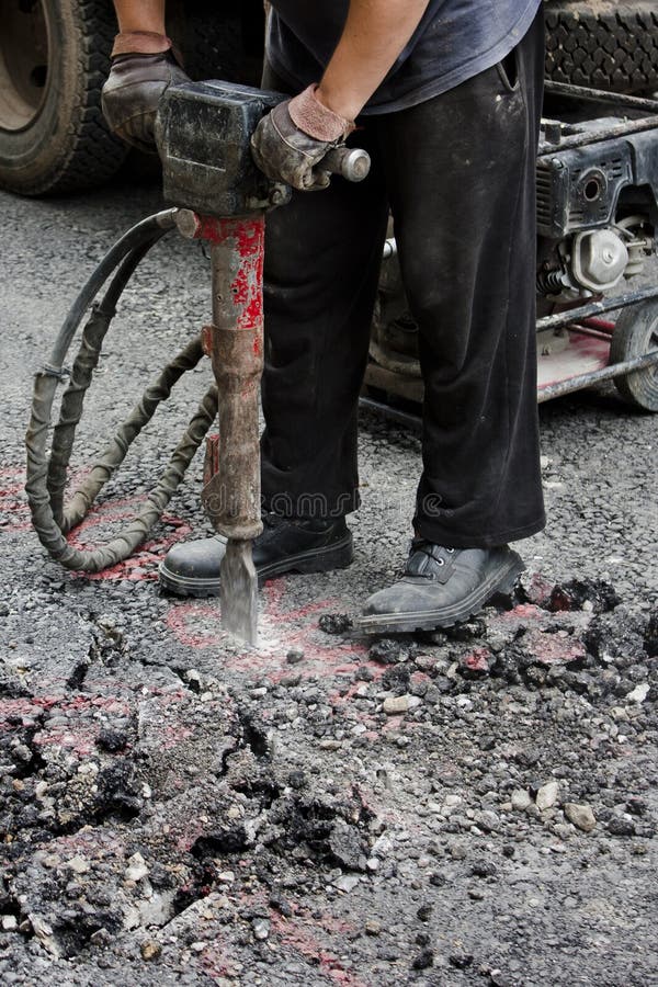 Worker jackhammering street. Shot from the waist down. Worker jackhammering street. Shot from the waist down.