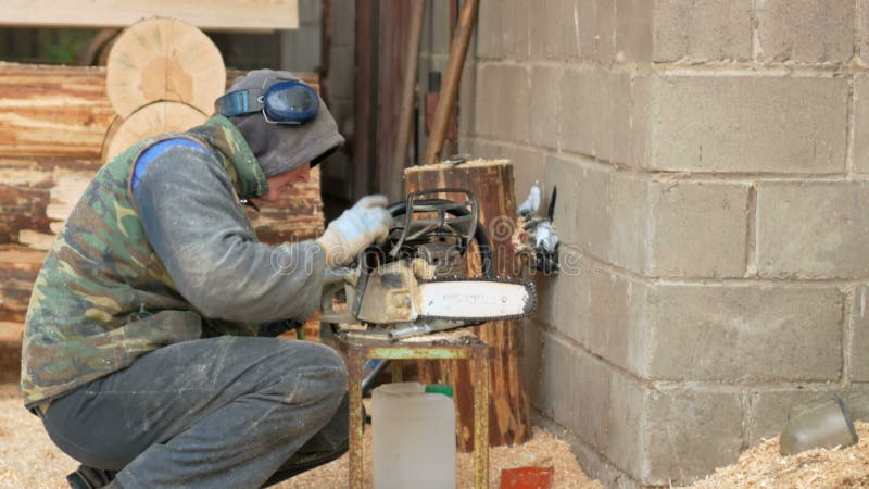 Arbeit leitet Verhinderungskettensäge Mann bauen auseinander und säubern das Werkzeug Bewegung der Kamera