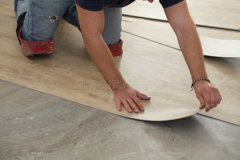 Arbeit über das Legen des Bodenbelags Arbeitskraft, die neuen Vinylfliesenboden installiert