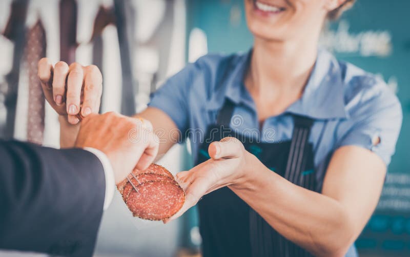 Arbeiten in Metzgerei - Verkäufer, der Fleisch zum cust übergibt stockfotografie Arbeiten in Metzgerei - Verkäufer, der Fleisch zum cust übergibt stockfotografie